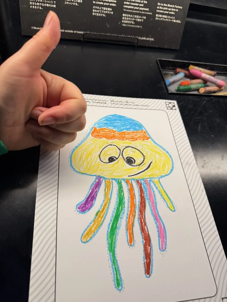 Our son's crayon drawing of a jellyfish with a thumbs up at teamLab Borderless
