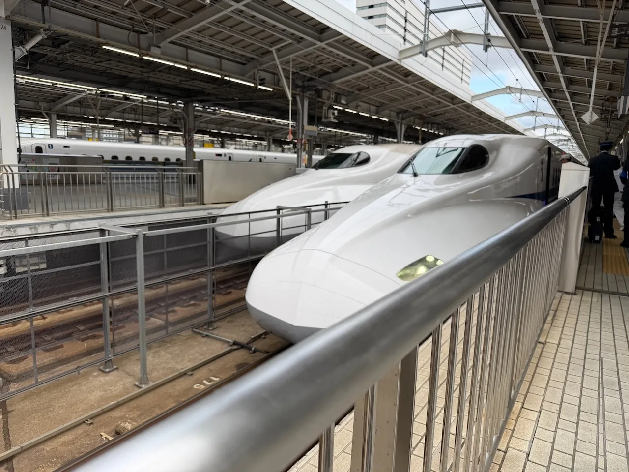 Two white Shinkansen trains side by side at the platform